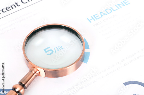 A magnifying glass is placed on a financial document