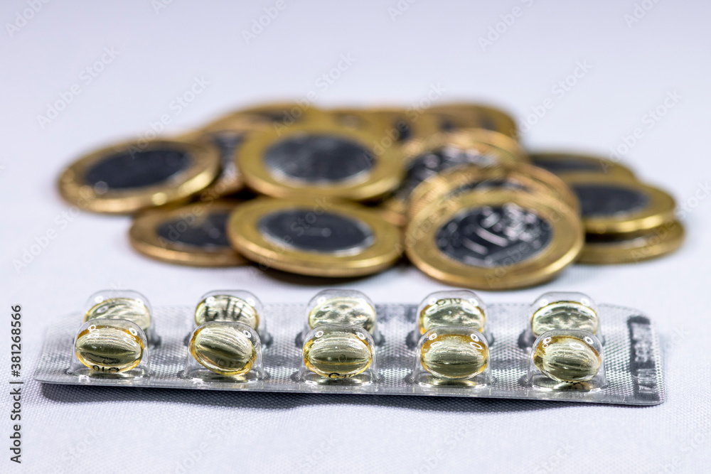 Macro shot pile of tablets pill in silver aluminium blister packaging with money coins background in Brazil Macro shot pile of tablets pill in silver aluminium blister packaging with money coins background in Brazil