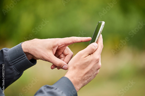 Close-up of a man using mobile smartphone. Selective focus