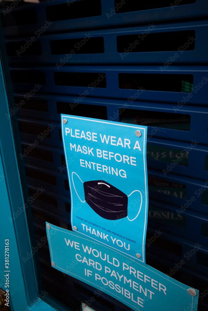 Φωτογραφία COVID 19 health and safety wear mask sign for shoppers in retail store window