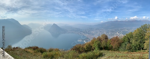 Foggy View of Monte San Salvatore Reflection in Lake and Coastline of the City of Lugano, Switzerland from Monte Bre (wide panoramic)