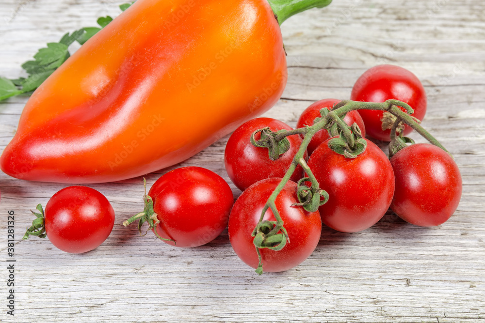 Freshly picked red cherry tomatoes against the bell pepper Freshly picked red cherry tomatoes against the bell pepper