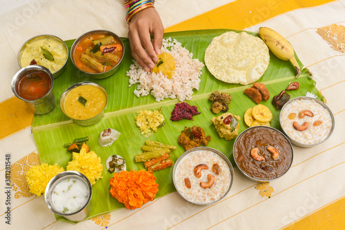 Onam sadhya, Indian women eating with hand boiled rice, served for Kerala Indian festival  with curries Sambar, Avial, Thoran, Papadum, Payasam, Banana, Yogurt or Buttermilk, banana chips photo