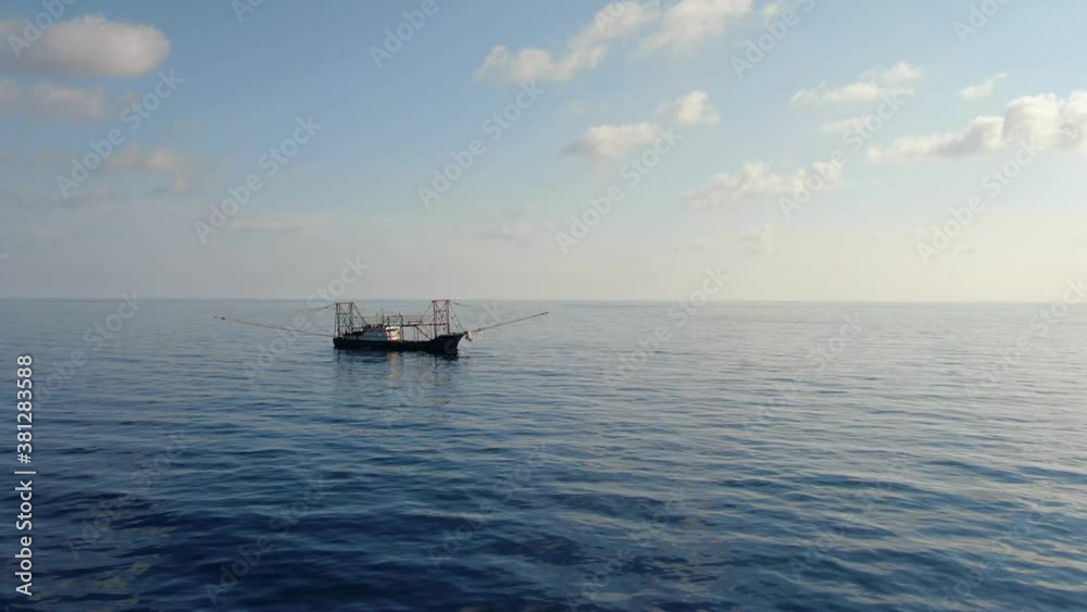 A fishing vessel catches fish in the open ocean. Aerial 4K shot.
