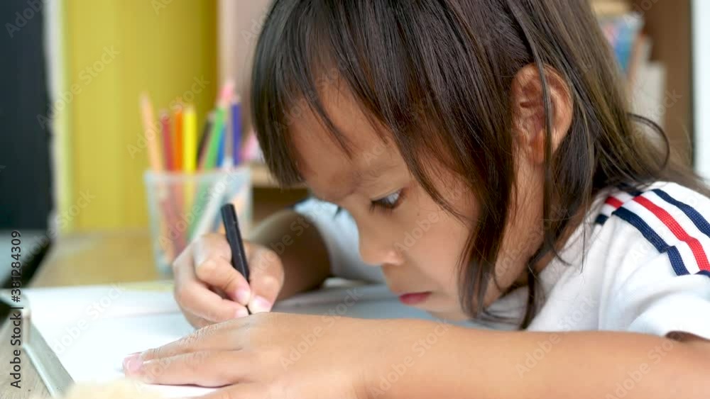 Cute little girl is painting by colored pencils in the paper at home. Cute little girl is painting by colored pencils in the paper at home.