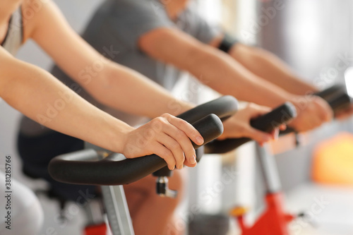 Young woman training on exercising bike in gym, closeup