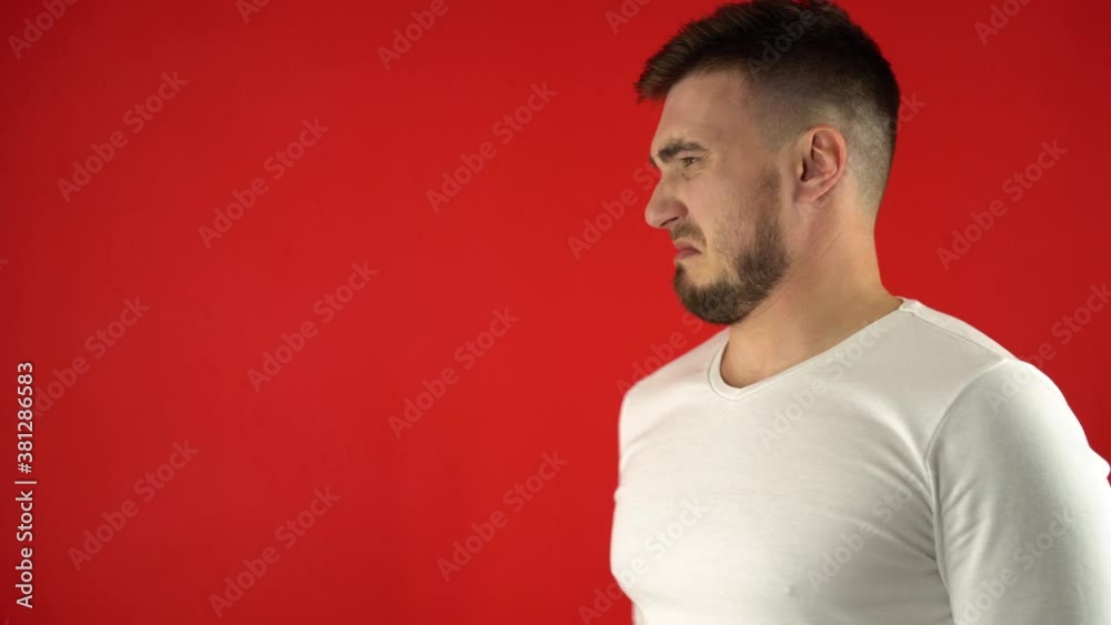 Portrait of a positive and satisfied man's householder using an aerosol air freshener. Home care concept. Isolate, 4k, red studio background.