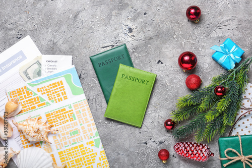 Composition with Christmas decor, map, and passports on grunge background