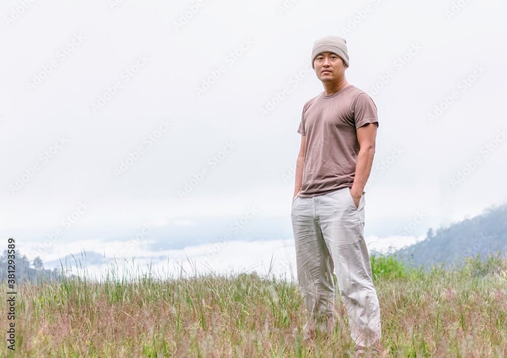 Asian young man standing on a mountain Asian young man standing on a mountain