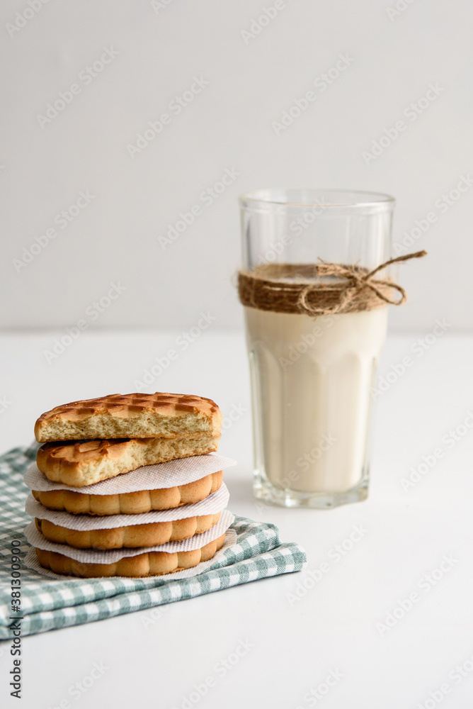 Cookies and a glass of milk close up on a linen napkin on a white background Cookies and a glass of milk close up on a linen napkin on a white background