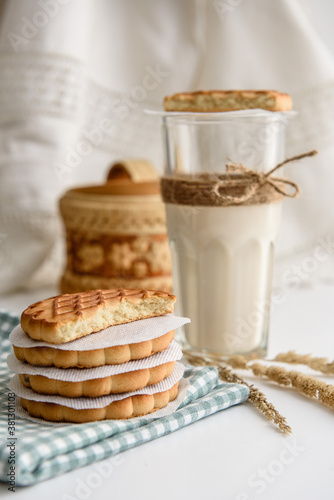 Cookies and a glass of milk close up on a linen napkin on a white background