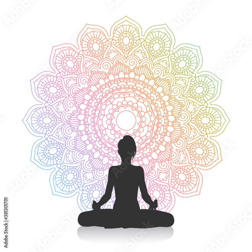 Silhouette of female in yoga pose against mandala design