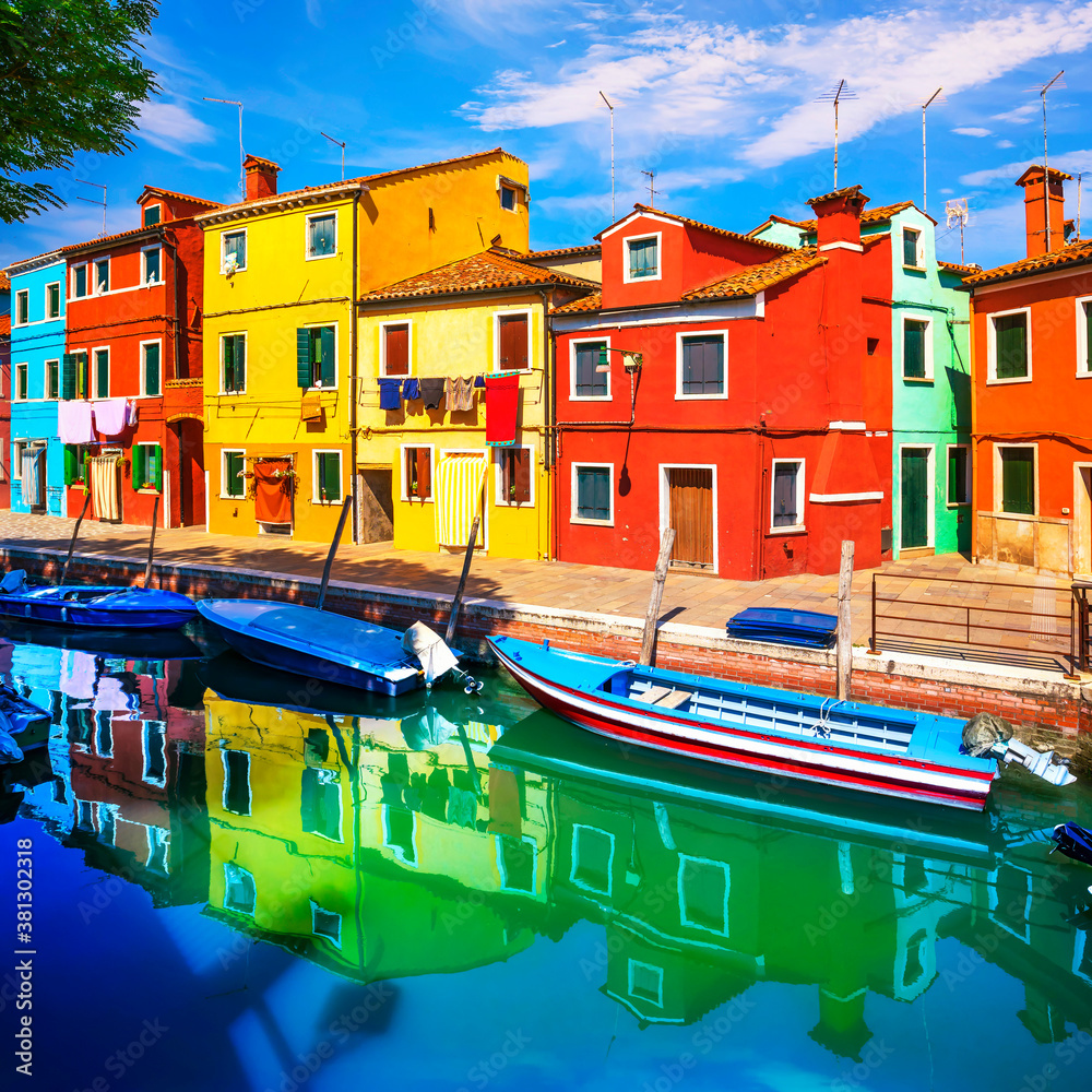 Burano island canal, colorful houses and boats in the Venice lagoon. Italy