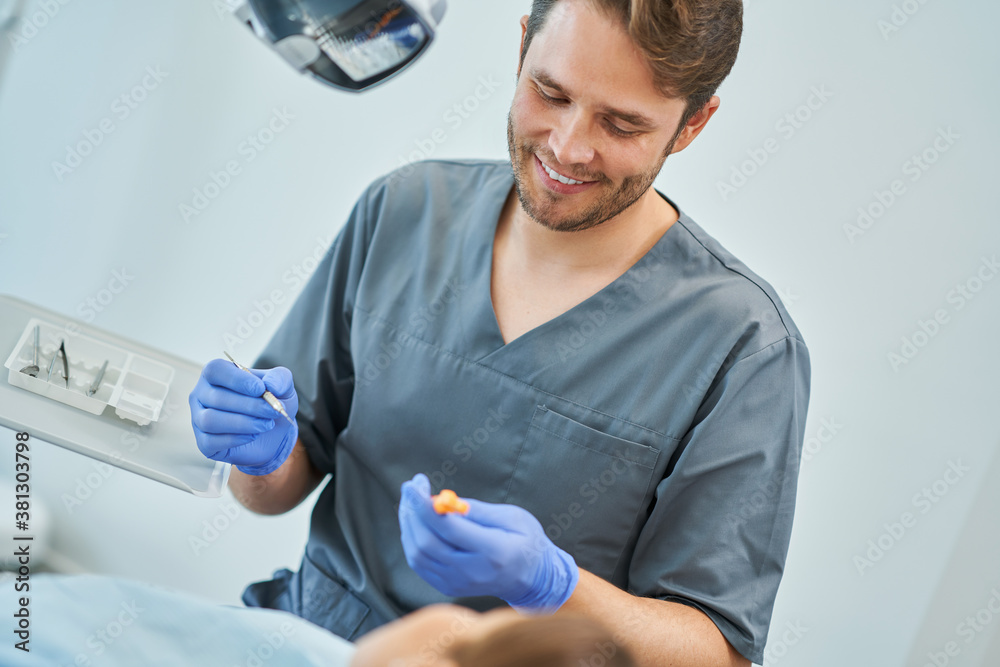 Male dentist and woman in dentist office Male dentist and woman in dentist office
