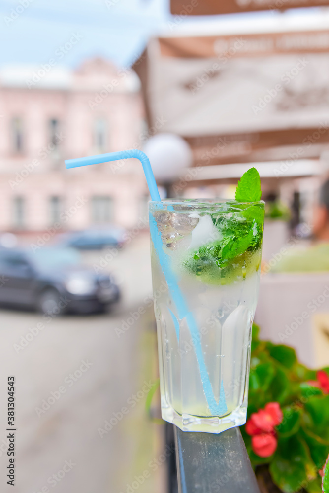 Cold summer fruit and berries lemonade. Mojito lemonade in a glass with a plastic straw outside. Cold summer fruit and berries lemonade. Mojito lemonade in a glass with a plastic straw outside.