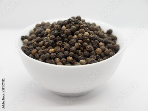 Black pepper, herbs, spices in a white bowl
