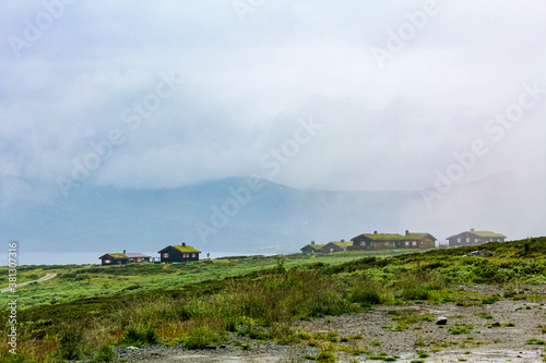 Obraz na plátně Norway landscape with fog clouds rocks cliffs with cabins Hemsedal