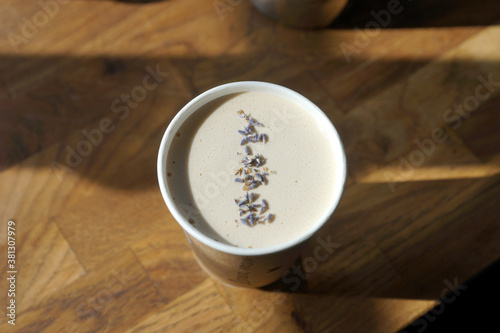 Barista prepares lavender creamy coffee in paper cup