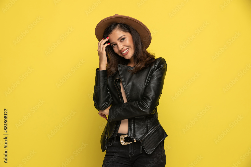 shy woman in leather jacket arranging hair shy woman in leather jacket arranging hair