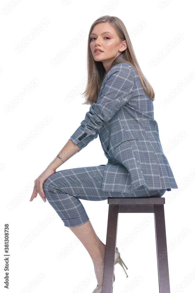 side view of sexy fashion model in blue checkered suit posing