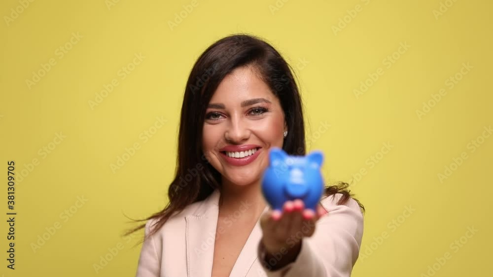 young businesswoman showing her piggy bank at the camera young businesswoman showing her piggy bank at the camera