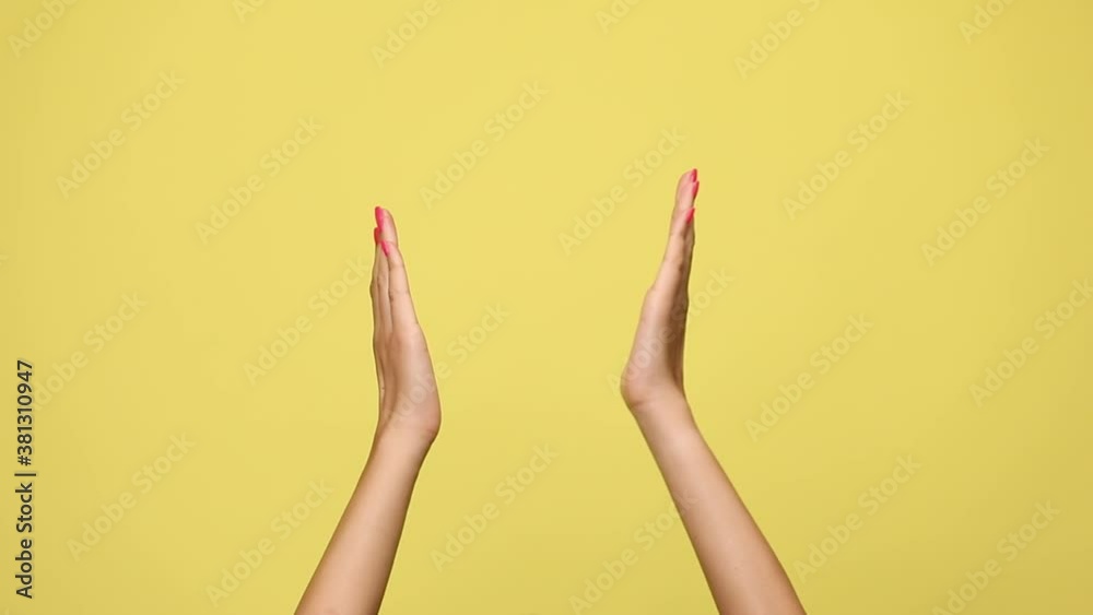 two arms are clapping and high fiving on yellow background two arms are clapping and high fiving on yellow background