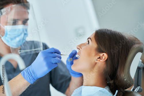 Male dentist and woman in dentist office