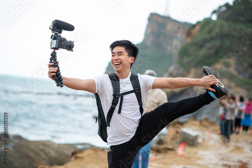 Vlogger holds and smile with his camera photo
