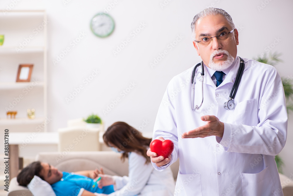 Two doctors visiting sick young man at home Two doctors visiting sick young man at home