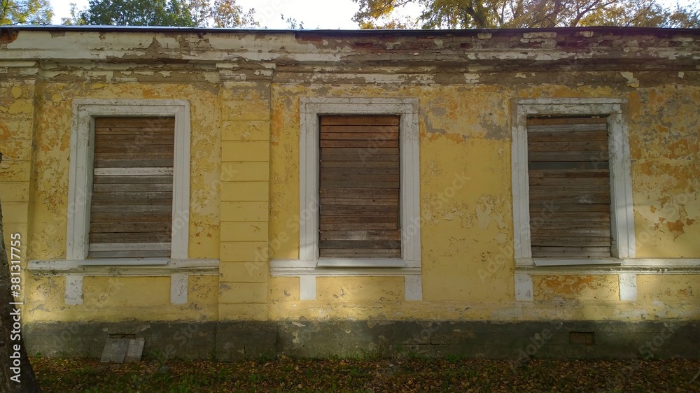 Old abandoned house in disrepair. Windows are filled with wooden planks instead of glass. Poverty, devastation, economic, financial and housing development crisis. Loneliness, sadness and despondency Old abandoned house in disrepair. Windows are filled with wooden planks instead of glass. Poverty, devastation, economic, financial and housing development crisis. Loneliness, sadness and despondency
