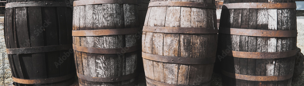 Old dirty weathered wooden barrels with rusty barrel hoops Old dirty weathered wooden barrels with rusty barrel hoops