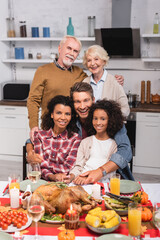 Selective focus of multicultural family embracing during thanksgiving celebration
