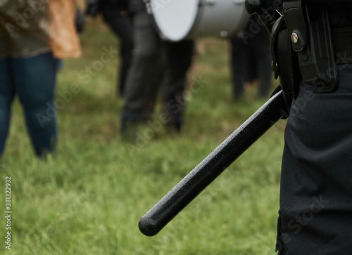 Baton on the belt of the black uniform of a German police officer