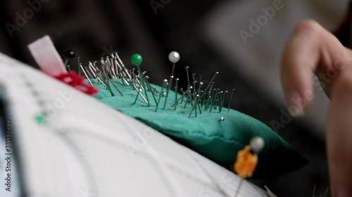 Video detail of bobbin lace handcrafting. Woman hands braiding threads to make a pattern.