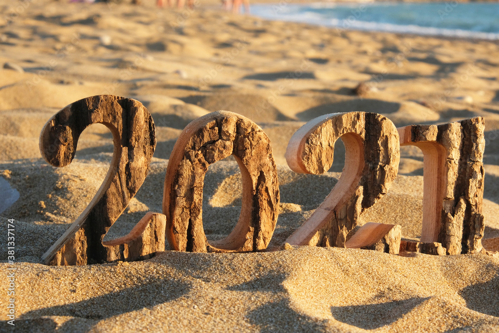Fototapeta premium Wooden figures 2021 on the coast of the river, against the background of the sea. Place for your text.