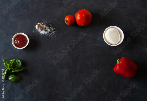 .Ingredients for Italian pizza on a dark background. Place for text