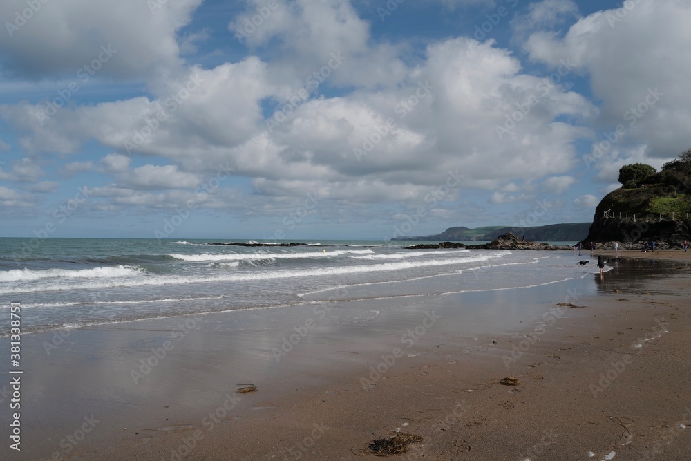 Aberporth beach on a sunny autumn day - clouds reflecting on the water on the sandy beach