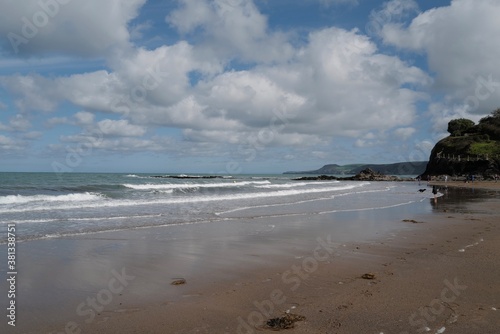 Aberporth beach on a sunny autumn day - clouds reflecting on the water on the sandy beach