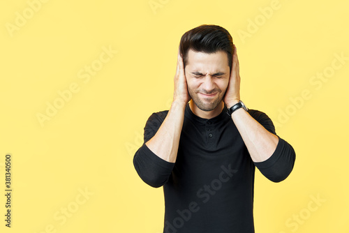 Handsome man covering his ears with hands afraid to hear bad news photo