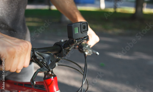 Action camera mounted on the handlebar of a bicycle that a male cyclist is holding