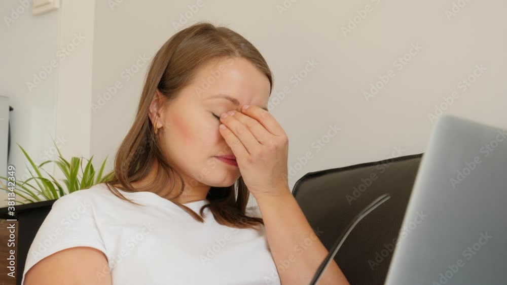 Home office woman portrait work on laptop computer take off glasses and massage tired eyes Home office woman portrait work on laptop computer take off glasses and massage tired eyes