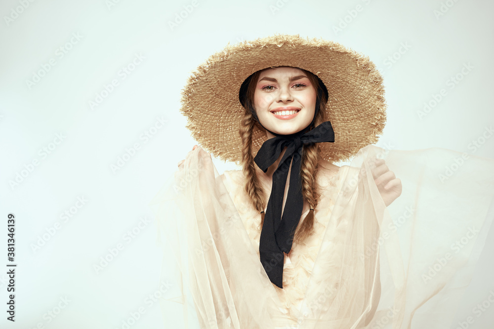 Nice girl in a straw hat with a black ribbon and in a dress on a light background romance model fun emotion Nice girl in a straw hat with a black ribbon and in a dress on a light background romance model fun emotion