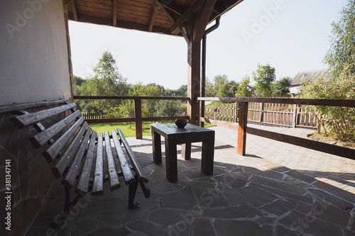 Wooden bench on the terrace of a country house - seating area overlooking the backyard