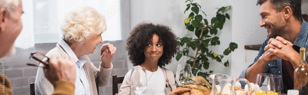 selective focus of joyful african american girl celebrating thanksgiving day with family, horizontal image