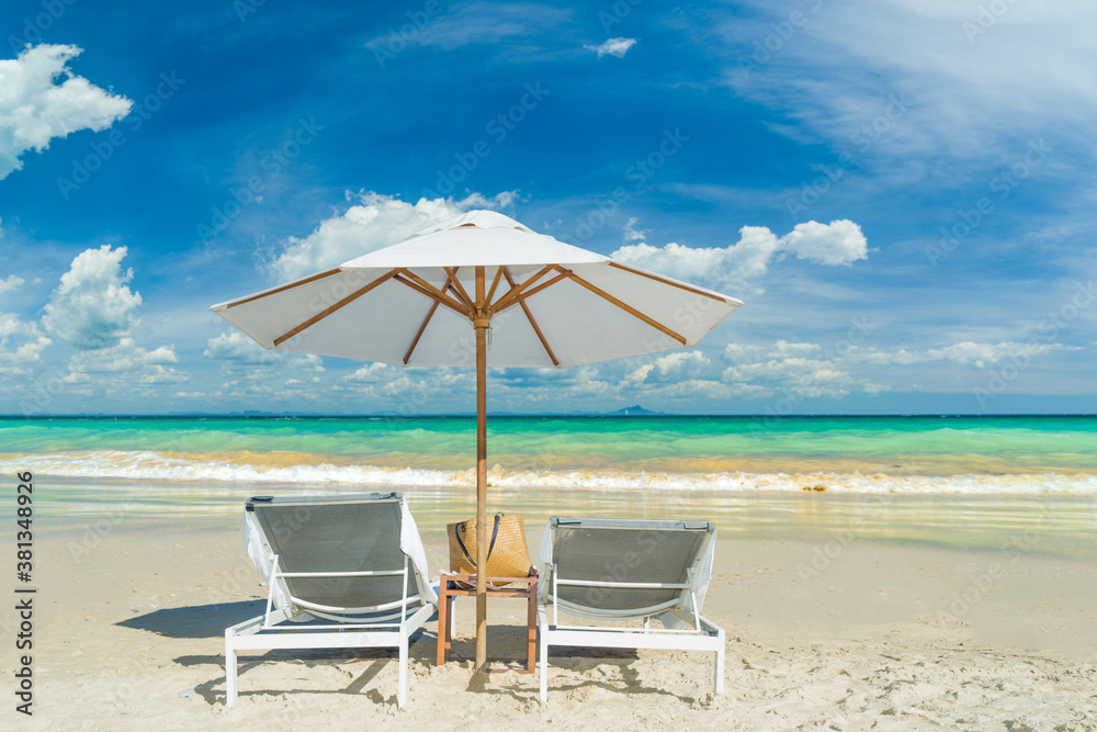 Beach chairs on the sand beach with cloudy blue sky