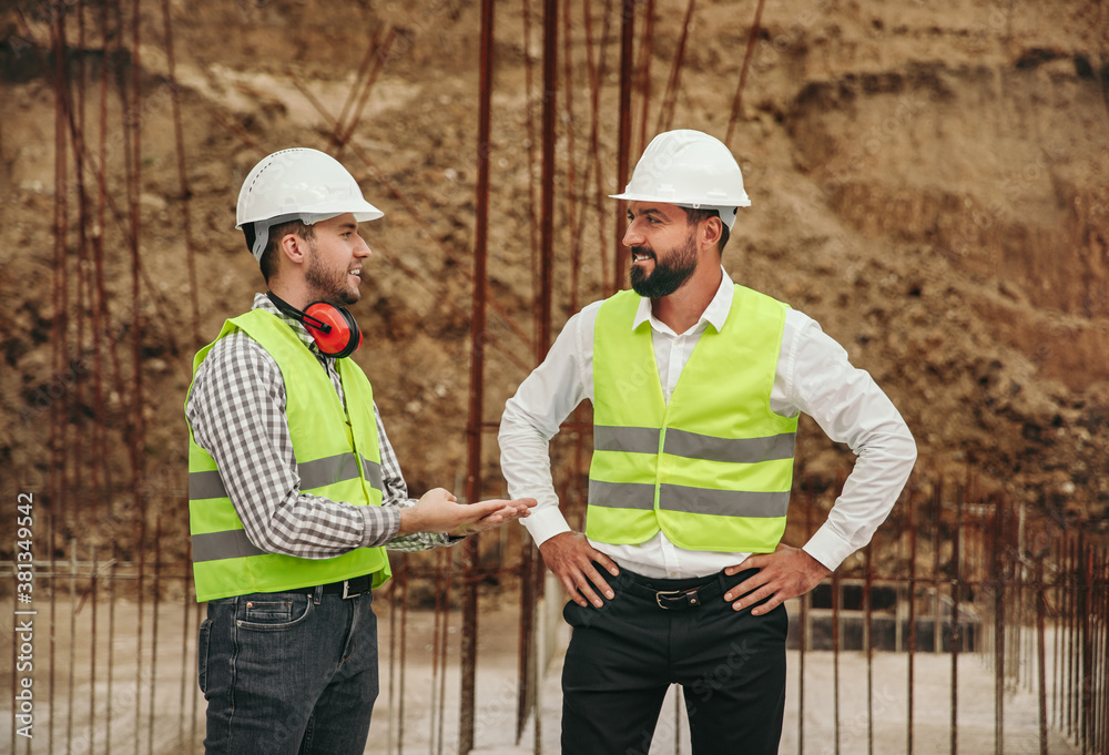 Male contractors speaking on construction site Male contractors speaking on construction site