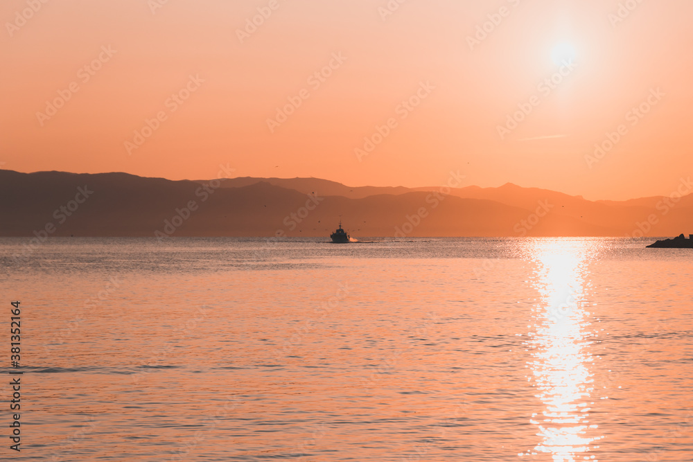 Panoramic view of a small yatch sailing on the beach of Marina Piccola in Cagliari at sunrise