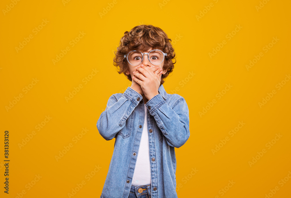 Amazed little boy covering mouth Amazed little boy covering mouth