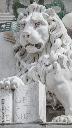 Winged lion with a Bible and a priest at Basilica San Marco in Venice, Italy, summer time, details, closeup