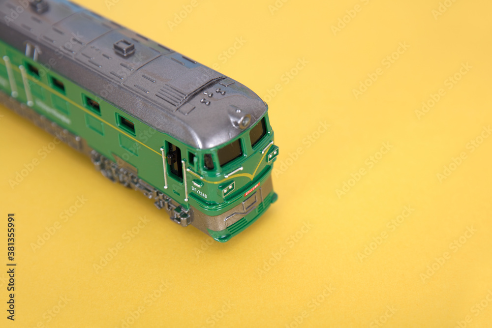 A model of a small train on a yellow background A model of a small train on a yellow background